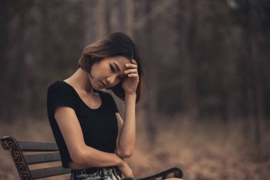 Asyalı güzel kız ormanda kendini yalnız hissediyor, üzgün kadın konsepti.