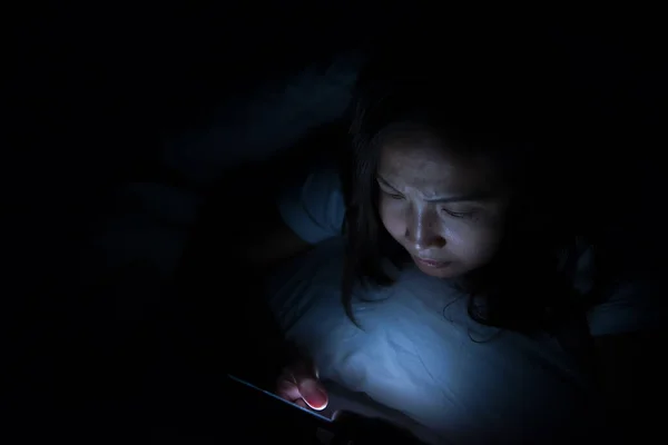 Asian woman play smartphone in the bed at night,Thailand people