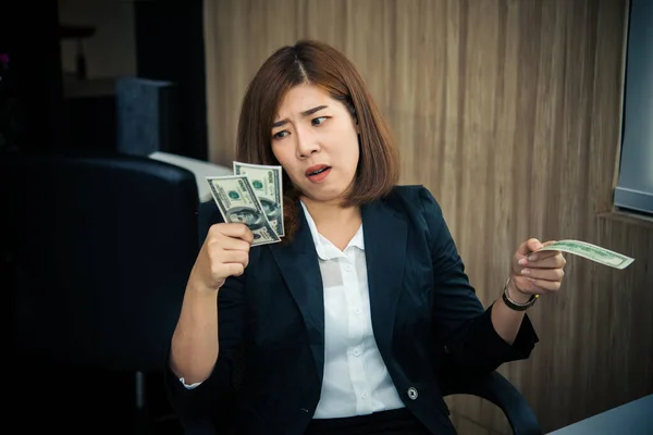 Asian woman working in office,young business woman stressed from work overload with a lot file on the desk,Thailand people Think so much about the salary that is not enough to spend.