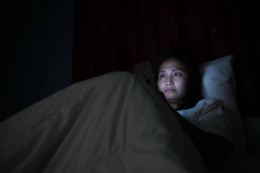 Asyalı kadın gece yatakta akıllı telefon çalar, Taylandlılar...