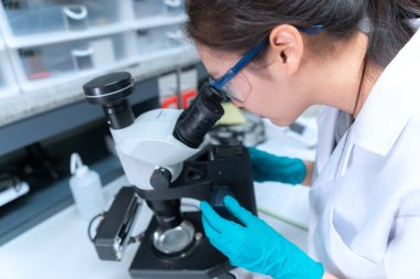 Laboratuvarda çalışan Asyalı bilim adamı araştırmacılar deneyin sonuçlarını araştırıyorlar.