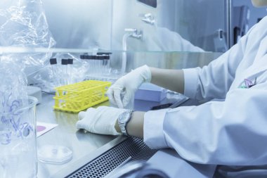 Bilim adamı deneyden önce kimyasalları sallama makinesiyle karıştırdı. Laboratuvarda çalışan Tayland 'lı bilim adamı test tüplerine numuneler karıştırdı.