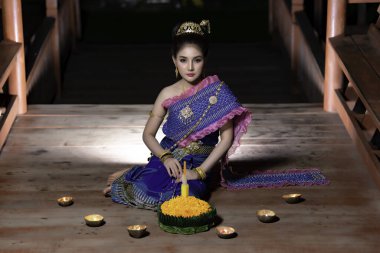 Portrait of beautiful asian woman in Thai dress traditional praying hold kratong for join loy kratong festival clipart