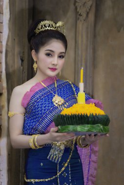 Portrait of beautiful asian woman in Thai dress traditional praying hold kratong for join loy kratong festival clipart