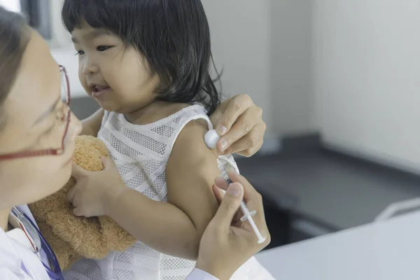 亚洲医生用听诊器检查一个可爱女孩的呼吸和心脏 — 图库照片