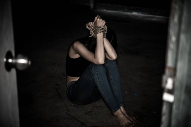 Asyalı rehine kadın. Gece vakti iple bağlanmış.
