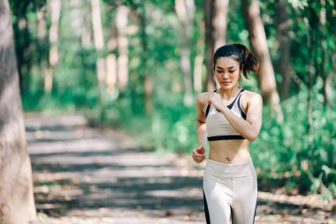 Parkta koşan Asyalı güzel kadın.