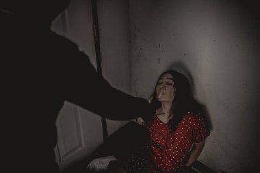 Asyalı rehine kadın. Gece vakti iple bağlanmış.