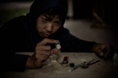 Asijský muž s drogami závislý na vstříknutí heroinu do jejich žil sami