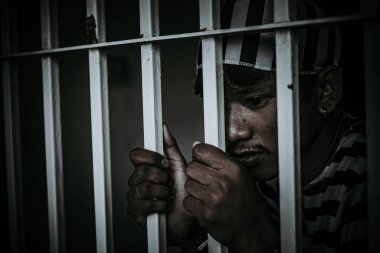 Demir hapishaneyi yakalamak için çırpınan bir adamın portresi, esir konsepti.