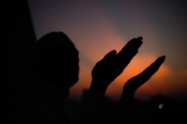Siluet Genç Asyalı Müslüman adam gün batımında dua ediyor, Ramazan festivali konsepti