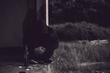 Üzgün Asyalı bağımlı dışarıda oturuyor.