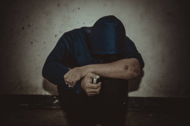 Uyuşturucu bağımlısı Asyalı bir adam damarlarına eroin enjekte ediyor.