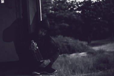 Üzgün Asyalı bağımlı dışarıda oturuyor.