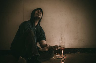 Uyuşturucu bağımlısı Asyalı bir adam damarlarına eroin enjekte ediyor.