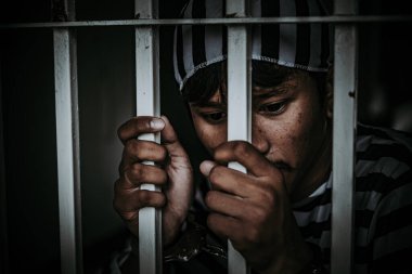 Demir hapishaneyi yakalamak için çırpınan bir adamın portresi, esir konsepti.