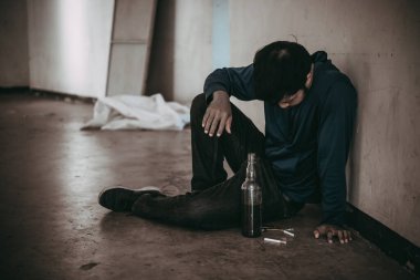 Uyuşturucu bağımlısı Asyalı bir adam damarlarına eroin enjekte ediyor.