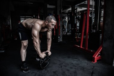 Asyalı bir adamın portresi. Spor salonunda büyük kas gücü, vücut ağırlığı eğitimi.