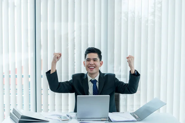 在办公室工作的时候 年轻的亚裔员工在笔记本电脑上工作 商人对办公室里的笑容 同事们的笑容感到满意 — 图库照片