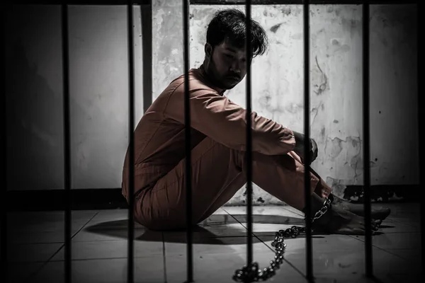 Asian man desperate at the iron prison, prisoner concept