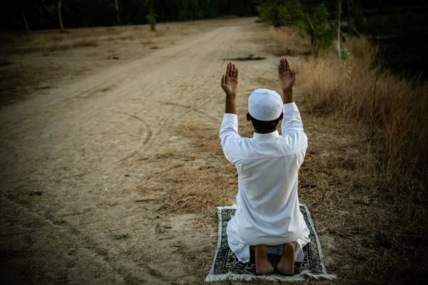年轻的亚洲穆斯林男子在夕阳西下祈祷 斋月的概念 — 图库照片