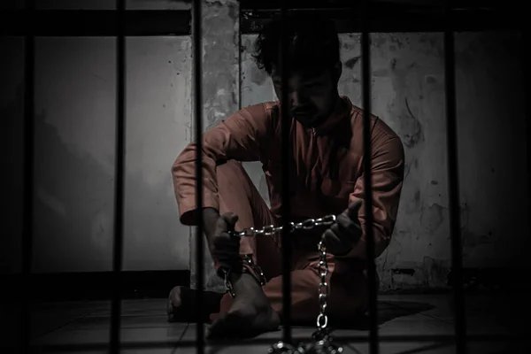 Asian man desperate at the iron prison, prisoner concept