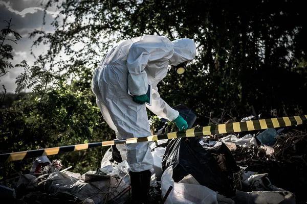 Asian scientist wear Chemical protection suit check danger chemical working at dangerous zone