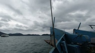 Bulutlu arka planda, denizdeki tekne manzarası 