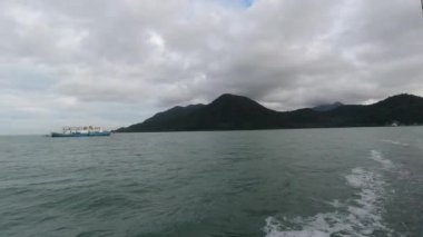 Bulutlu arka planda, denizdeki tekne manzarası 