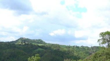 Gündüz vakti yeşil ağaçların üzerindeki bulutlu gökyüzü manzarası