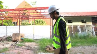 Dizüstü bilgisayarı olan erkek mühendis yapı için nesneyi kontrol ediyor, iş için yeni konum  