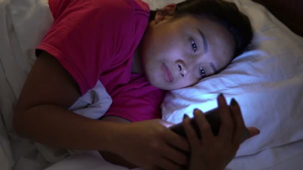 亚洲女人晚上在床上玩智能手机 — 图库视频影像