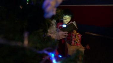 Noel Baba, çocuk için evdeki Noel festivalinde masal okuyor.