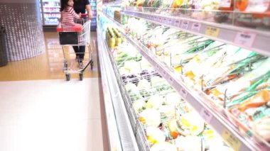Anne ve tatlı kız süpermarkette ürün seçiyorlar. 