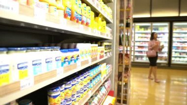 Anne ve tatlı kız süpermarkette ürün seçiyorlar. 