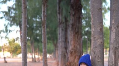 Küçük Asyalı kızın portresi park ormanında kışlık kıyafetler giyer.