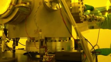 Laboratuvarda çalışan koruyucu toz kıyafeti giyen bilim adamları