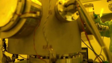 Laboratuvarda çalışan koruyucu toz kıyafeti giyen bilim adamları