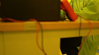 Laboratuvarda çalışan koruyucu toz kıyafeti giyen bilim adamları