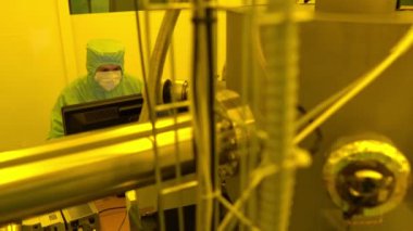 Laboratuvarda çalışan koruyucu toz kıyafeti giyen bilim adamları