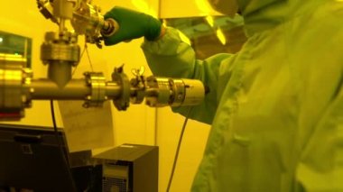 Laboratuvarda çalışan koruyucu toz kıyafeti giyen bilim adamları