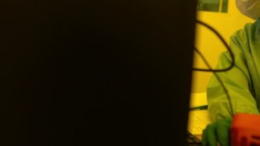 Laboratuvarda çalışan koruyucu toz kıyafeti giyen bilim adamları