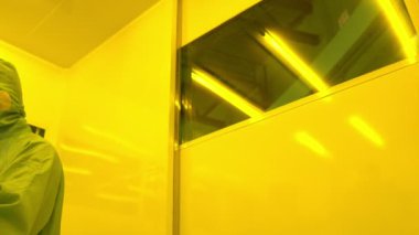 Laboratuvarda çalışan koruyucu toz kıyafeti giyen bilim adamları