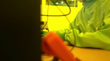 Laboratuvarda çalışan koruyucu toz kıyafeti giyen bilim adamları