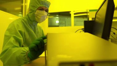 Laboratuvarda çalışan koruyucu toz kıyafeti giyen bilim adamları