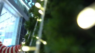 Noel ağacının yanında Noel Baba şapkası takan sevimli Asyalı küçük kız portresi