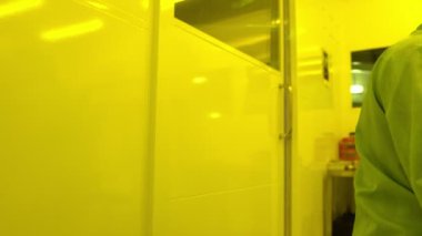 Laboratuvarda çalışan koruyucu toz kıyafeti giyen bilim adamları