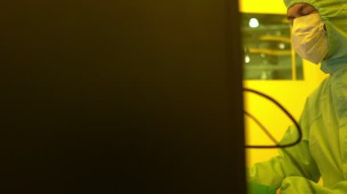 Laboratuvarda çalışan koruyucu toz kıyafeti giyen bilim adamları