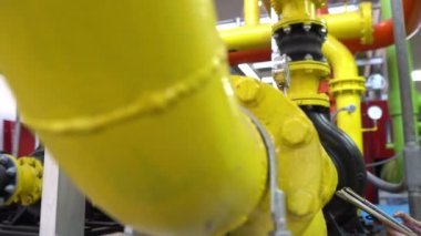 Kazan dairesinde çalışan gözlüklü Asyalı mühendis ısıtma sistemi ekipmanlarının teknik verilerini kontrol ediyor.