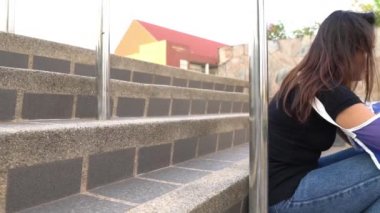 Alçılı genç Asyalı kadın dışarıda kendine acır. 